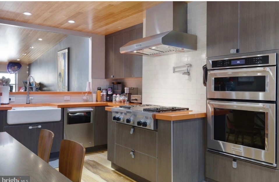 Chef's kitchen with wood ceiling and professional range