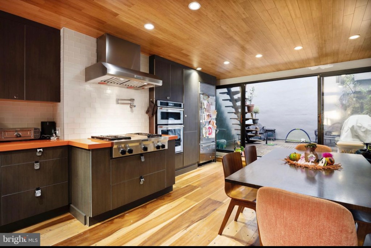 Residential kitchen with wood ceiling, professional range, and outdoor access