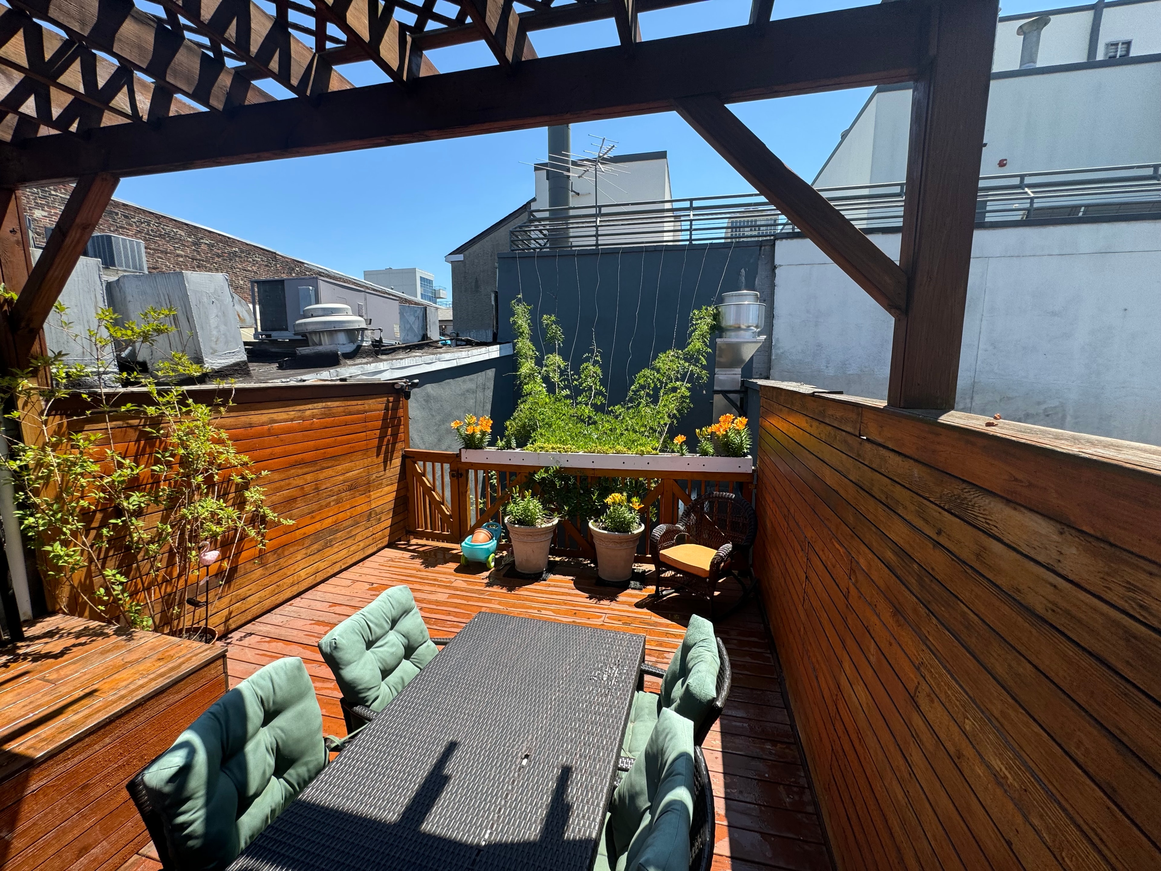 2nd floor roof deck dining area with pergola overhead